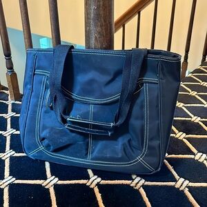 Nine W. Carry bag with front zipper, snap top, and mini compartments inside
